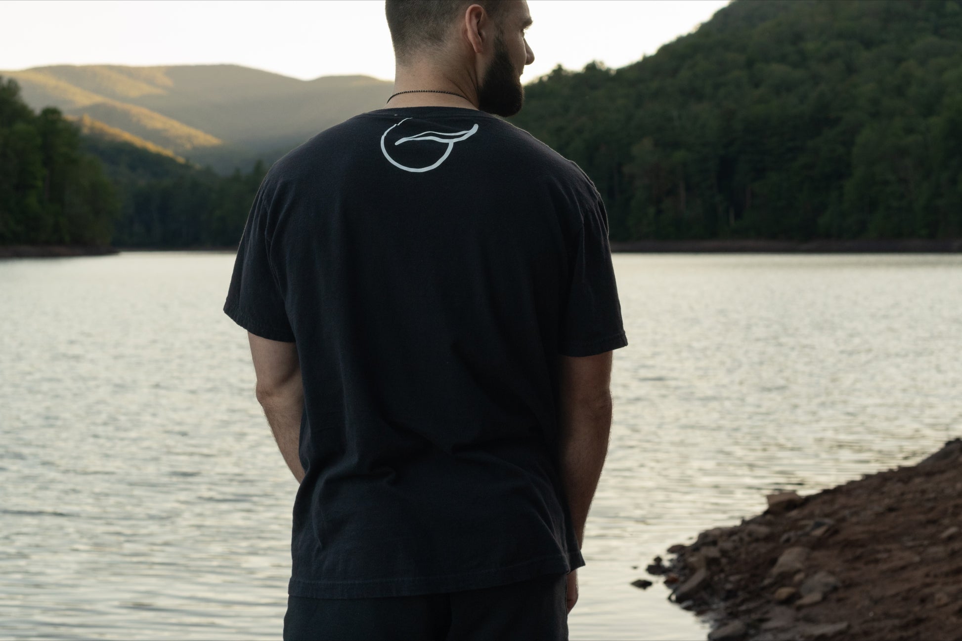 Back of a Black Short Sleeve Organic Cotton T Shirt With the Breath Emblem Between the Shoulder Blades.