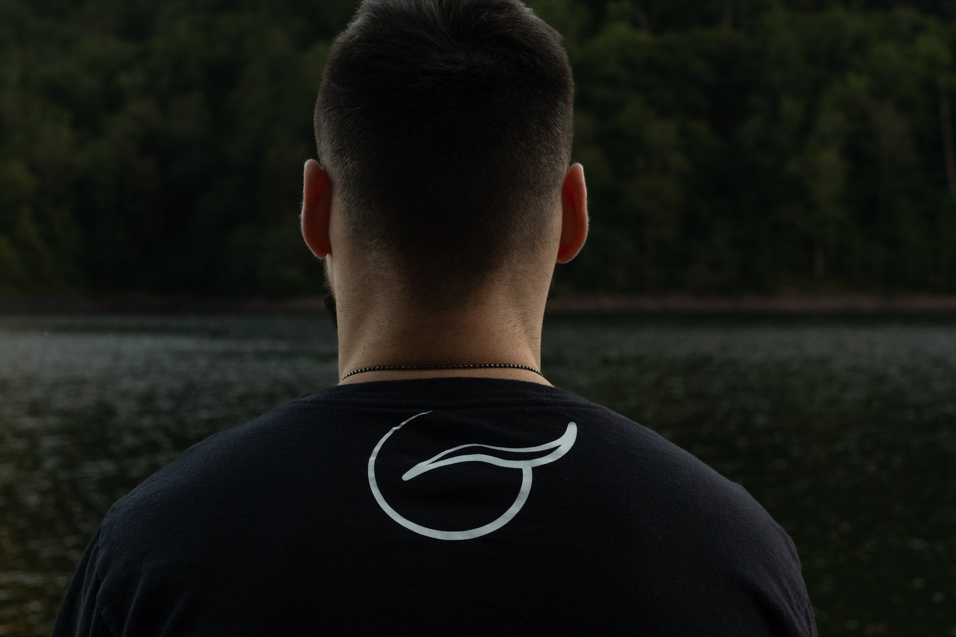 Picture of the Upper Back of a Black Organic Cotton Short Sleeve T shirt with the Breath Emblem Between the Shoulder Blades.